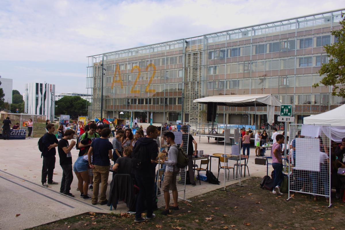 Devant le bâtiment A22 de l’Université de Bordeaux, des étudiants découvrent diverses associations, et se prêtent à des animations organisées par celles-ci.