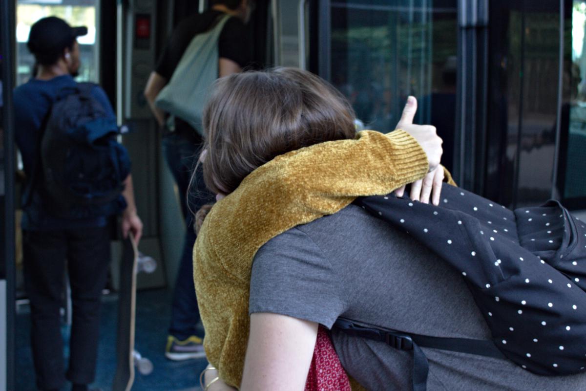 Une étudiante enlace une inconnue près d'un arrêt de tramway bordelais.