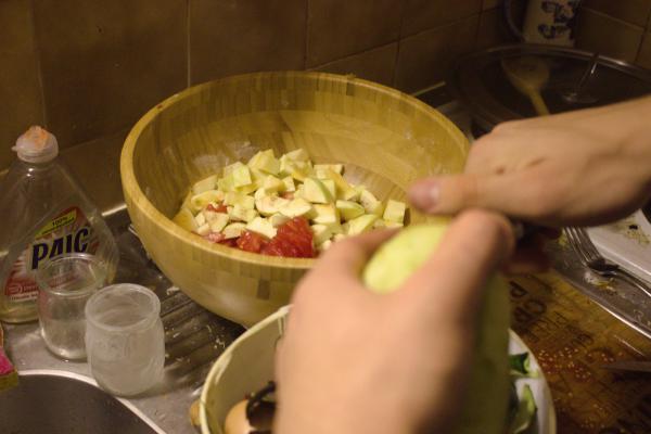 Une personne épluche et coupe des légumes.