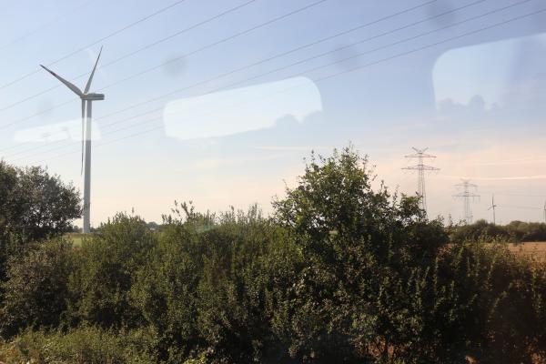 Des éoliennes dans un champ plat, vu depuis mon train.
