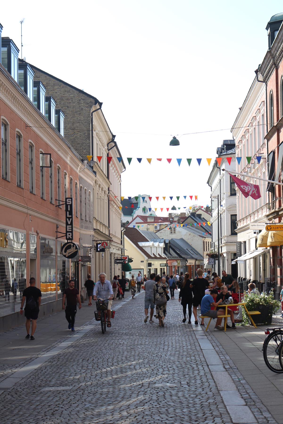 De nombreuses personnes sur la Rue Lilla Fiskaregatan à Lund, sans masque. Sur la droite, les terrasses des bars et restaurants sont bondés. La distanciation sociale n'est pas très respectée…